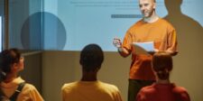 Guest blogging for backlinks: how to build links that actually improve rankings A man giving a presentation to a seated audience in a classroom or workshop setting.