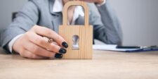 How to create a secure website people can trust Woman holding a wooden padlock on a desk, representing website security and protection.