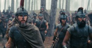 Armoured warriors moving through a wooded battlefield in a scene from The Odyssey.