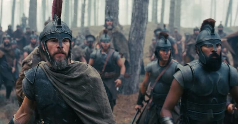 Armoured warriors moving through a wooded battlefield in a scene from The Odyssey.