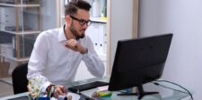 Website security checklist: 21 checks to audit your site Man working at a desktop computer in an office.