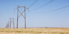 Bell’s $52.5B Saskatchewan AI plan puts local infrastructure in the spotlight Power lines stretching across a prairie field under a clear blue sky.