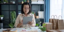 Small business owner reviewing purchases and inventory on a tablet.