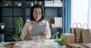 Small business owner reviewing purchases and inventory on a tablet.