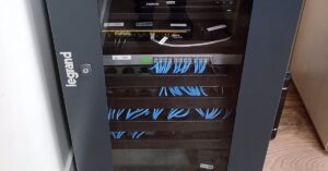 Network equipment rack with connected Ethernet cables and enterprise networking hardware.