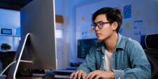 Cloudflare’s new AI crawler controls put SEO and content protection in the same dashboard Web professional working at a desktop computer in a blue-lit office.