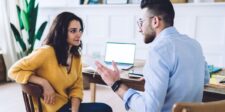 Conversion optimization for small business websites: turn more visitors into leads Two business professionals discussing ideas across a table with a laptop in the background.