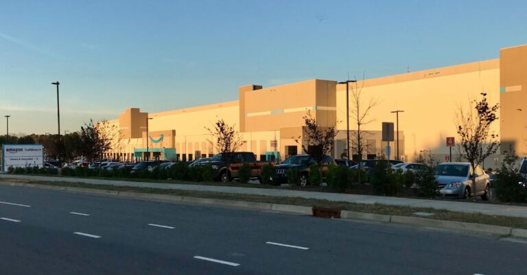 Amazon fulfillment center in Garner, North Carolina, with cars parked outside the warehouse.