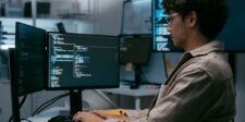 GitLab CVSS 10 flaw is under active exploitation Developer working at a computer with multiple monitors displaying code.