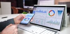 Person reviewing digital advertising analytics on a laptop and smartphone.