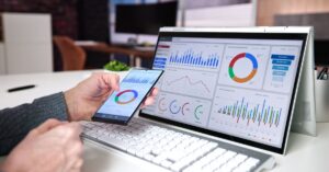 Person reviewing digital advertising analytics on a laptop and smartphone.