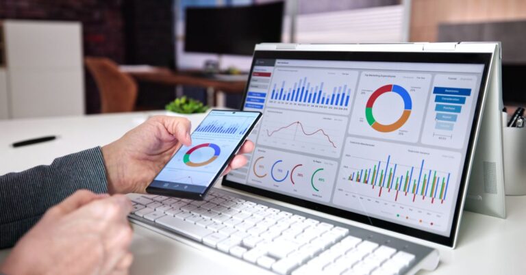 Person reviewing digital advertising analytics on a laptop and smartphone.