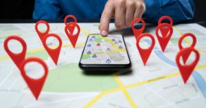 Smartphone displaying a map surrounded by location pins representing nearby businesses.