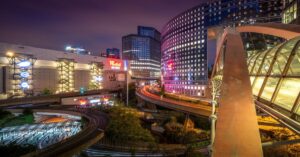Night view of La Défense in Paris with office towers, elevated roads, and the illuminated Westfield shopping centre.