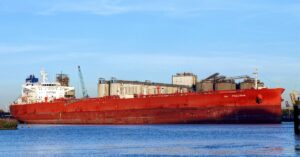 Crude oil tanker On Precious docked beside industrial port facilities.