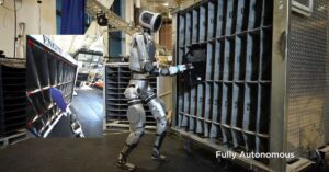 Boston Dynamics Atlas humanoid robot performing parts-sequencing work in a factory training environment.