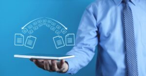 Business professional holding a tablet beneath digital icons representing secure file transfers.