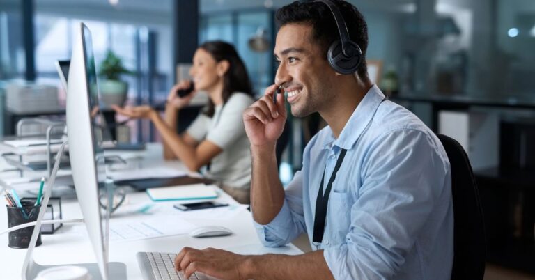 Customer service workers handling phone calls at computer workstations.