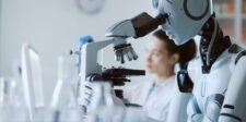 MIT robot builds and repairs a laser experiment on demand Humanoid robot using a microscope beside a scientist in a laboratory.