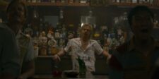 Netflix’s Cliff Booth strategy turns streaming into an event Man seated at a dimly lit bar surrounded by bottles and vintage decorations in a film scene.