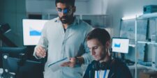 Australia reviews AI safety rules after OpenAI agent accesses Medicare portal Two technology professionals reviewing computer systems and data in an office.