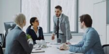 Business executives discussing a proposed deal around a conference table.