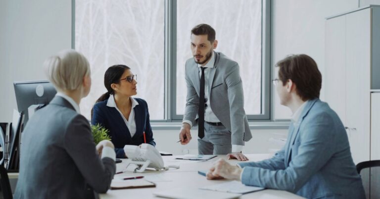 Business executives discussing a proposed deal around a conference table.