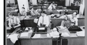 Reporters working at desks with typewriters in the New York Times newsroom in 1942.