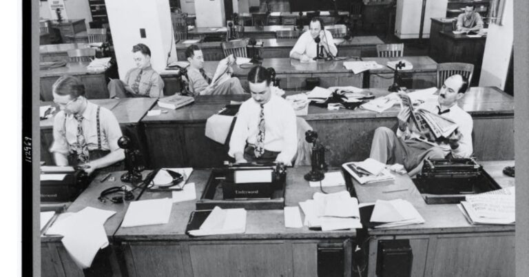 Reporters working at desks with typewriters in the New York Times newsroom in 1942.