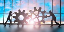 SaaS technical SEO: how to build a software site Google can crawl, index, and trust Silhouettes of two businesspeople pushing interlocking gears in front of large windows at sunset, representing technical systems working together.