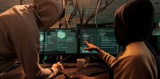 Extorting the extorters: ShinyHunters’ public fight with Cl0p Two hooded people reviewing code and system activity across multiple computer monitors.
