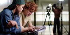 The Social Reckoning puts Facebook’s past under legal scrutiny Film production team reviewing a script on set with a camera in the background.