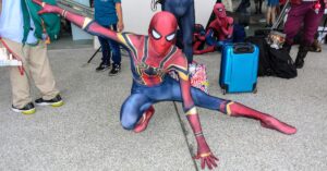 Spider-Man cosplayer striking a crouched superhero pose at the Bring It On 5 cosplay event.