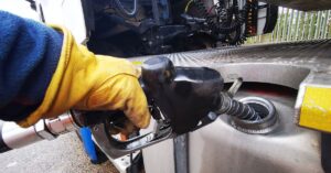 Diesel fuel nozzle filling a commercial truck’s fuel tank.