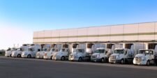 7-Eleven may bring more supply-chain work in-house as inflation bites Row of refrigerated delivery trucks outside a distribution facility, illustrating 7-Eleven’s review of bringing more supply-chain operations in-house.