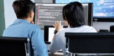 AI agents reportedly tested the locks on government websites Two cybersecurity professionals reviewing code and system activity on multiple computer screens.