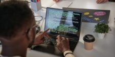Why AI coding agents may not speed up software delivery yet Developer reviewing code on a laptop, illustrating research showing AI coding agents increase code output while adding pressure to code review.