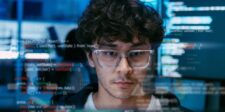 Apple’s token-free AI pitch comes with limits Software developer working with code displayed across multiple computer screens.