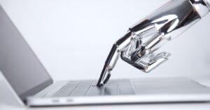 Robotic hand pressing a key on a laptop keyboard