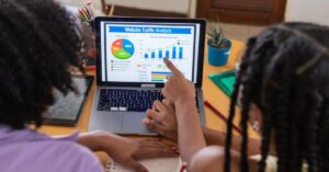 Two people reviewing website traffic analytics on a laptop, illustrating how ChatGPT referrals may be misclassified as Direct traffic.
