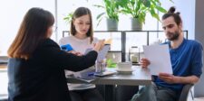 Commercial loan refinance: how to decide before you apply Business owners reviewing commercial loan documents with a financial advisor during a refinancing discussion.