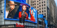 Digital out-of-home advertising: a practical guide for businesses Large digital billboards displaying entertainment ads above a busy city street, illustrating digital out-of-home advertising.