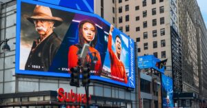 Large digital billboards displaying entertainment ads above a busy city street, illustrating digital out-of-home advertising.