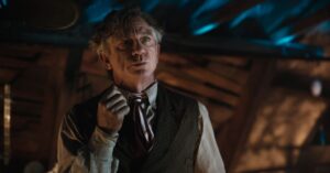 Character from Greta Gerwig’s Narnia: The Magician’s Nephew shown in a dimly lit scene from the film’s first trailer.