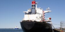 Gulf of Oman oil transfers hit capacity as tanker costs rise Large oil tanker docked at a port with another vessel visible offshore.