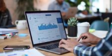 HubSpot closes legacy private app creation for existing accounts Hands using a laptop displaying business charts on a shared office table.