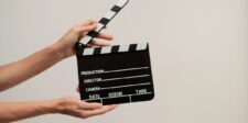 James Bond search reaches reported final screen tests Hands holding an open black-and-white film clapperboard against a beige background.