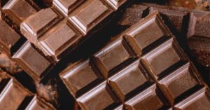 Close-up of stacked chocolate bars and broken pieces.