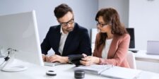 Making an LLC: a practical guide before you file Business professionals reviewing financial records and documents at a computer while preparing to form an LLC.