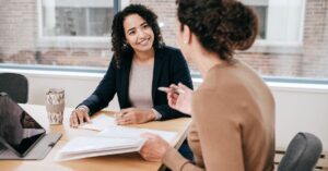 Business owner and marketing professional reviewing contract documents during a client meeting.